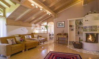 A cozy living room with a comfortable couch and a wood stove. Large windows let in plenty of light and create an inviting atmosphere.
