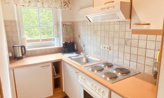 A bright kitchen with modern appliances and a window that provides natural light. The room is clean and well-organized.