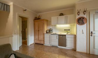 A cozy kitchen with modern appliances and a wooden cabinet. The room has light walls and an inviting floor.