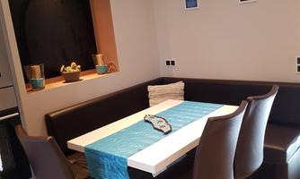 A modern dining area with a table and elegant chairs. The walls are decorated and there is a cozy atmosphere.