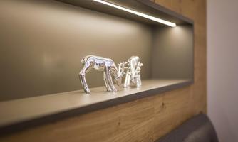 An elegant display of silver animal figures on a shelf. The subtle lighting highlights the beautiful details of the figures.