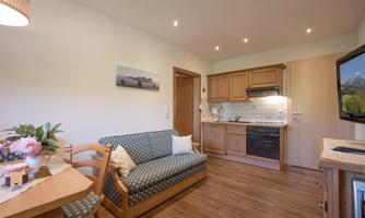 A cozy apartment with a small kitchenette and a dining area. The space is bright and furnished in a modern style, perfect for relaxed moments.