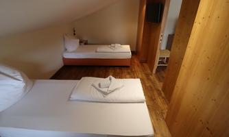 A spacious room with two single beds and a friendly wooden interior. It is bright and simply furnished, ideal for a peaceful stay.