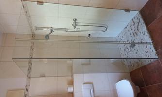 A modern bathroom with a glass shower and white tiled wall. The space feels bright and inviting.