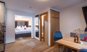 A cozy room with a dining area and a separate bedroom. The decor is modern and inviting.