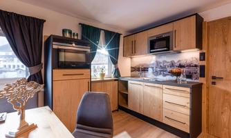 A modern kitchen with wooden cabinets and an elegant design. The space is bright and cozy, ideal for cooking and relaxing.