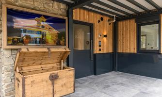 An inviting entrance area with a wooden box and a large picture on the wall. The walls are made of wood and stone, creating a cozy atmosphere.