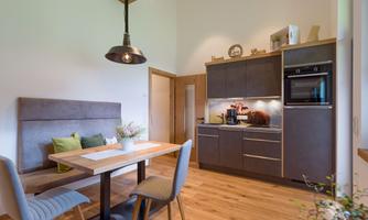 Modern kitchen with wooden details and a dining area. Bright colors create an inviting atmosphere.