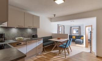 Modern kitchen unit with open living area. Bright spaces and comfortable seating create an inviting atmosphere.