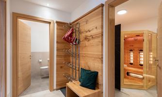A modern entrance area with wooden paneling. On the right side, there is a sauna, while a toilet is visible on the left.