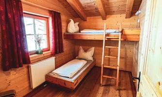 Zweibettzimmer Ein gemütliches Schlafzimmer mit Holzverkleidung. Es gibt ein Etagenbett, ein Einzelbett und ein Fenster mit roten Vorhängen. 