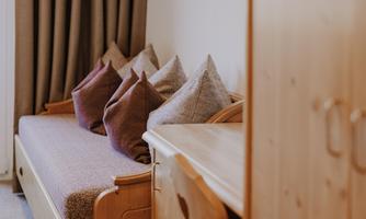 A cosy room with a sofa bed and several cushions.