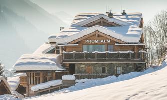 Winter magic at the celebrity lodge. Nestled in the snowy mountain landscape, the celebrity lodge majestically towers over the valley. The rustic facade made of natural stone and reclaimed wood, covered in shimmering snow, gives the chalet a fairy-tale character. Spacious panoramic windows and the surrounding balcony offer a dreamy view of the winter mountain world – a retreat full of tranquility and alpine charm.