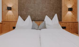 A cosy Double Room Attic with a double bed and large white pillows.