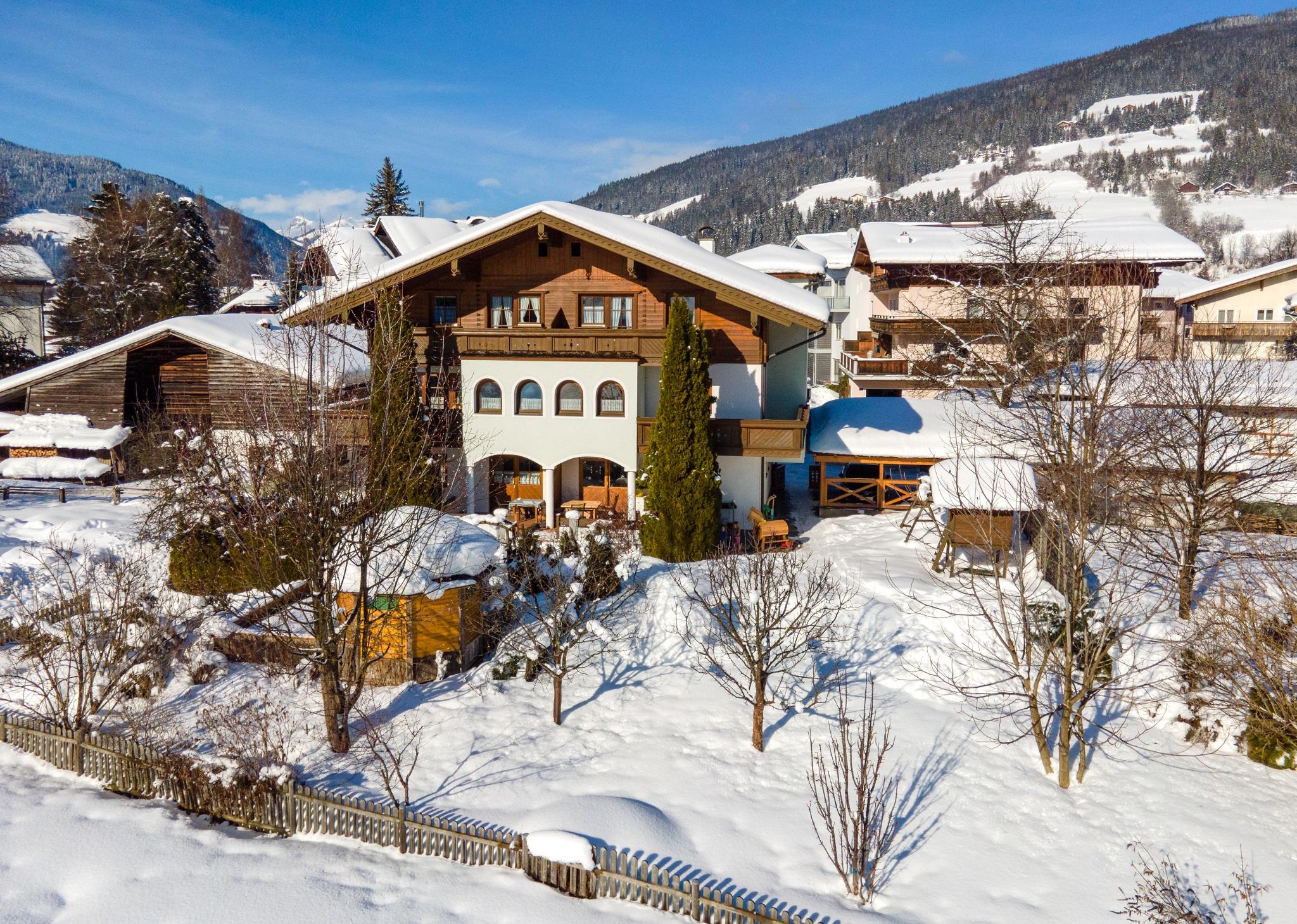 A picturesque house in a snow-covered landscape with mountains in the background. The surroundings are calm and idyllic, perfect for a winter vacation.