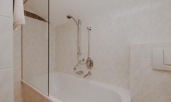 A modern bathroom with a bathtub and a shower partition.