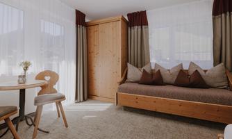 A cosy room with a sofa and large windows.