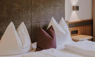 A cosy Family Room with two white pillows and one purple pillow.