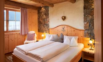 Enjoy restful nights in our lovingly furnished bedroom in traditional Alpine style. Warm wooden tones, cozy details, and atmospheric lighting create a comfortable feel-good atmosphere. Whether after a hike or a day on the ski slopes – here you will find the peace you deserve. Ideal for couples or those seeking relaxation who want to combine alpine flair with comfort.