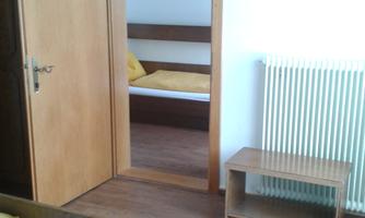 A simple bedroom with two beds and yellow blankets.