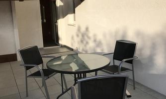 A cozy outdoor area with a table and chairs. From the terrace, you can see directly onto the surrounding mountains and the garden.