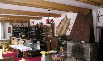 A cozy room with a wooden ceiling and an open fireplace. The room is warmly furnished and offers an inviting atmosphere.