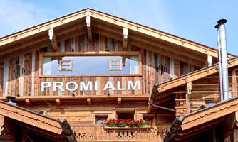 The Celebrity Alm – an alpine highlight with character. A real eye-catcher with recognition value: The Celebrity Alm presents itself in traditional old wood construction with a modern touch. The large panoramic window in the gable, artistically decorated balconies, and bright red geraniums emphasize the rustic charm of this special house. The striking lettering "PROMI ALM" makes it immediately clear: Here one resides in style – with alpine flair and a touch of exclusivity.
