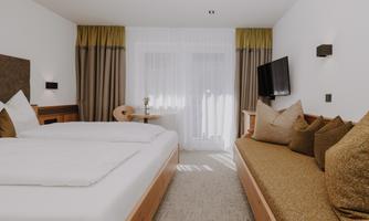 A modern Double Room Comfort with a double bed and a cosy seating area.
