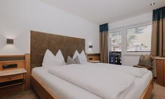 A cosy Double Room Basic with a large bed and two decorative pillows.