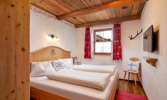 Enjoy restful nights in our lovingly furnished bedroom in traditional Alpine style. Warm wood tones, cozy details, and atmospheric lighting create a comfortable atmosphere for relaxation. Whether after a hike or a day on the ski slopes – here you will find the peace you deserve. Ideal for couples or those seeking relaxation who want to combine Alpine charm with comfort.