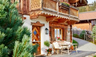 Quaint chalet with loving details and sunny terrace. The charming facade of this chalet combines traditional craftsmanship with alpine coziness. Rustic wooden furniture with sheepskins on the sunny terrace in front of the entrance invites you to linger. Lovingly carved balconies and natural materials create a cozy atmosphere – ideal for a cup of coffee in the morning or a delightful break in the last rays of sunlight of the day.