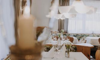 A cosy restaurant with set tables and soft lighting.