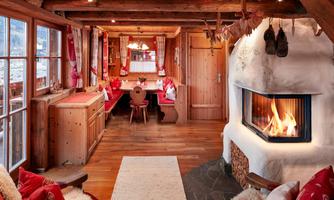 Rustic living room with fireplace and traditional corner bench. Cozy living room in traditional Alpine style with modern comfort. The comfortable tiled stove provides cozy warmth and invites relaxation. The large, surrounding corner bench with soft cushions and heart-decorated pillows offers a perfect spot for shared meals or sociable hours with family and friends. Rustic wooden beams, natural materials, and loving details like embroidered curtains, wood carvings, and decorative elements create an authentic and inviting atmosphere – ideal for unforgettable cabin moments with panoramic views into the valley.
