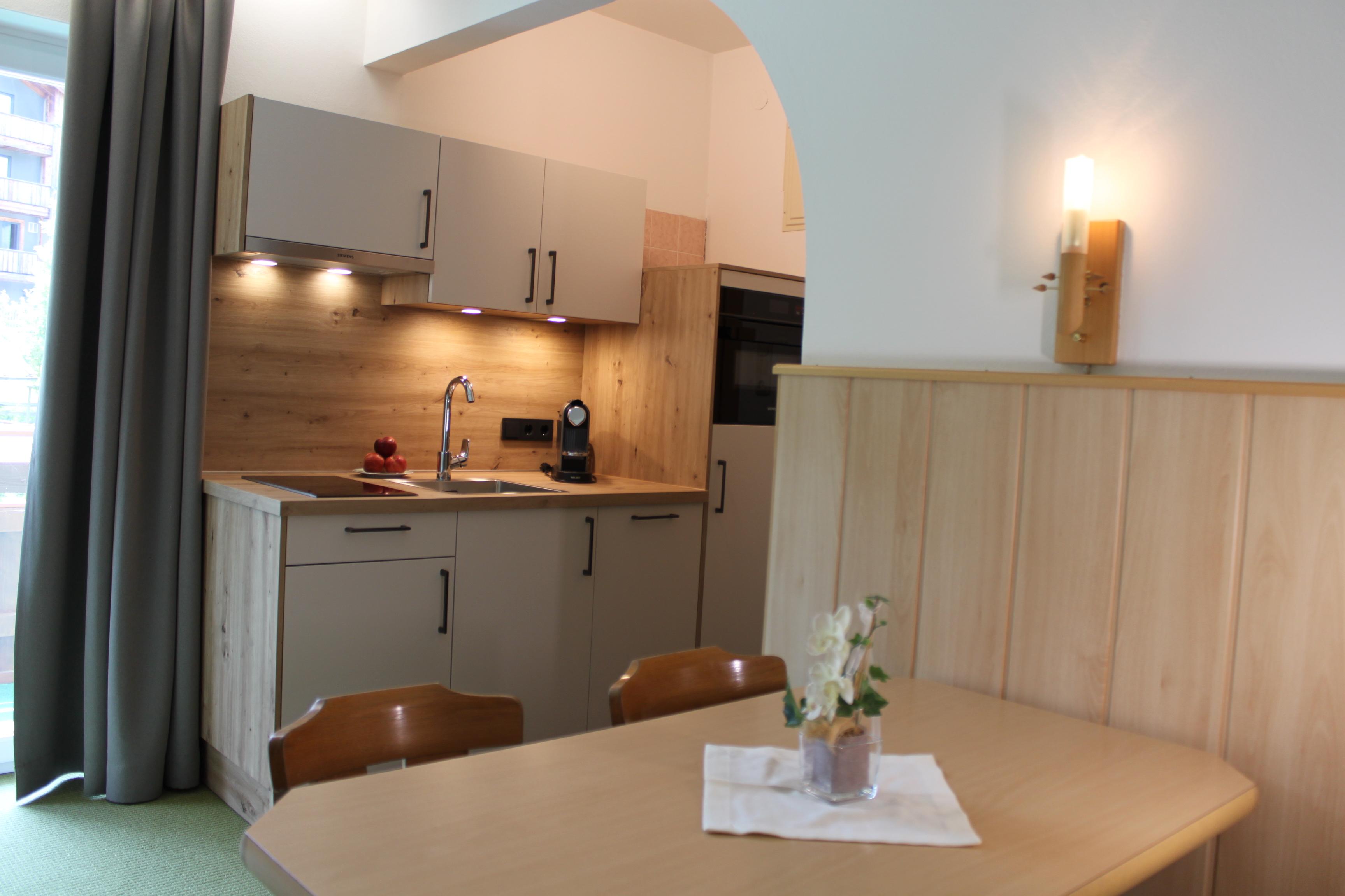 A modern kitchen with wooden shelves and an edible table. The room is bright and inviting with beautiful decorative elements.