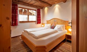 Enjoy restful nights in our lovingly furnished bedroom in traditional Alpine style. Warm wood tones, cozy details, and atmospheric lighting create a comfortable feel-good atmosphere. Whether after a hike or a day on the ski slopes – here you will find the peace you deserve. Ideal for couples or those seeking relaxation who want to combine Alpine flair with comfort.
