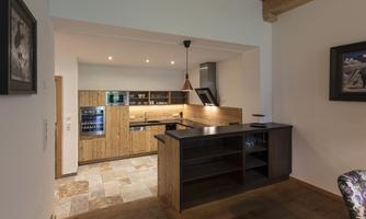 Modern kitchen with wooden cabinets and a central island. Bright lighting creates an inviting atmosphere.