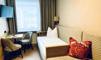 A cozy room with a single bed and a relaxing atmosphere. A small table and chairs provide space for working or dining.