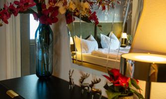 An elegant room with a mirror and stylish decoration. On the table, there are flowers and small decorative figures.