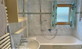 A bathroom with a bathtub, a sink, and a toilet.