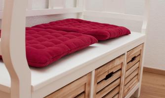 A cozy bench with red cushions and wooden drawers underneath. The room feels bright and inviting.