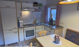 A cozy kitchen area with modern appliances and a dining table. Bright colors and plenty of space create a pleasant atmosphere.