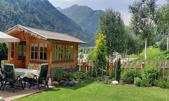 A cozy holiday home in the mountains, surrounded by green meadows and trees. The sunny garden invites you to relax.