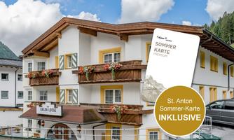 A cozy hotel with balconies and blooming flowers. The summer card for St. Anton is included.