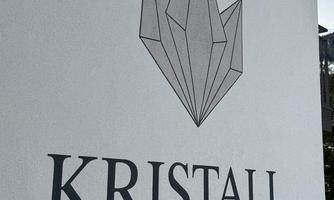 A wall with the inscription "KRISTALL" and a stylized crystal graphic. The text is black on a white background.