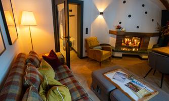 A cozy room with a modern fireplace and an inviting sofa landscape. The warm colors and soft light create a comfortable atmosphere.