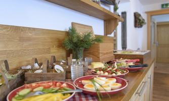 A rich breakfast buffet with fresh vegetables, eggs, and various salads. The tables are inviting and well-decorated.