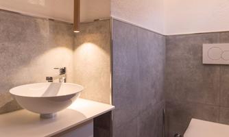 A modern bathroom with an elegant vanity solution. The walls are designed in a simple gray style.