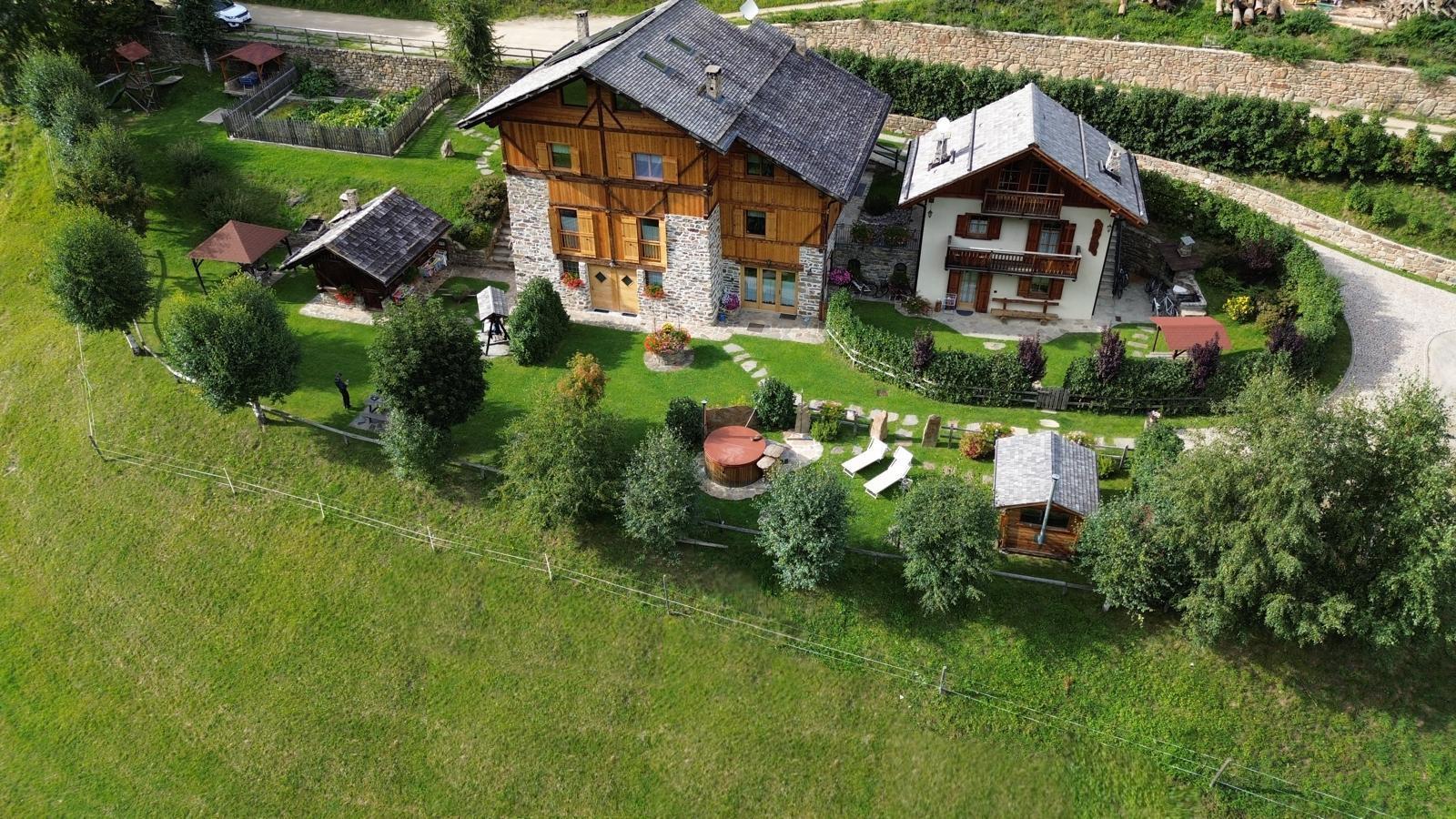 Chalet Canedi seen from above and surrounded by meadows.
