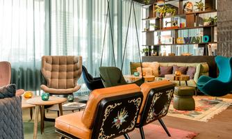 A stylish living room with modern furniture and a cozy atmosphere. Large windows provide plenty of daylight and an inviting environment.