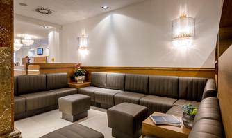 A modern waiting area with comfortable seating. The walls are bright, and the lighting creates a pleasant atmosphere.